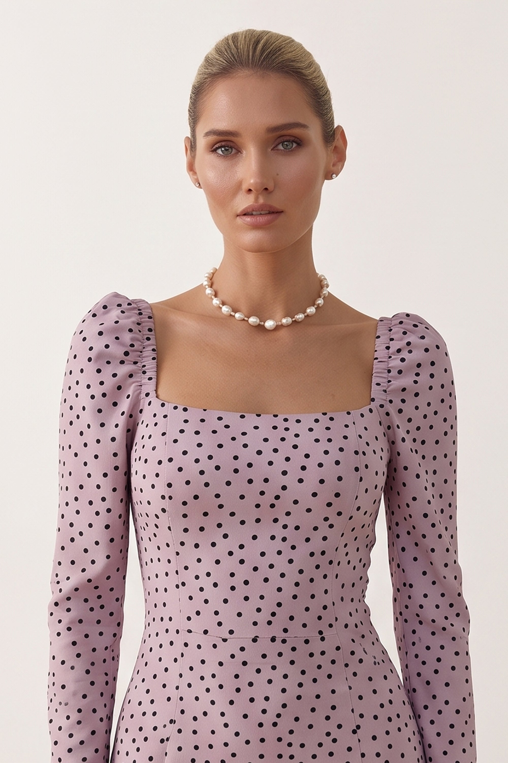 Close up view of a woman wearing the pink Celestra Midi Dress by FemeAdor featuring a flattering fit-and-flare silhouette and timeless polka dot pattern