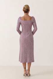 Back view of a woman wearing the pink Celestra Midi Dress by FemeAdor featuring a flattering fit-and-flare silhouette and timeless polka dot pattern