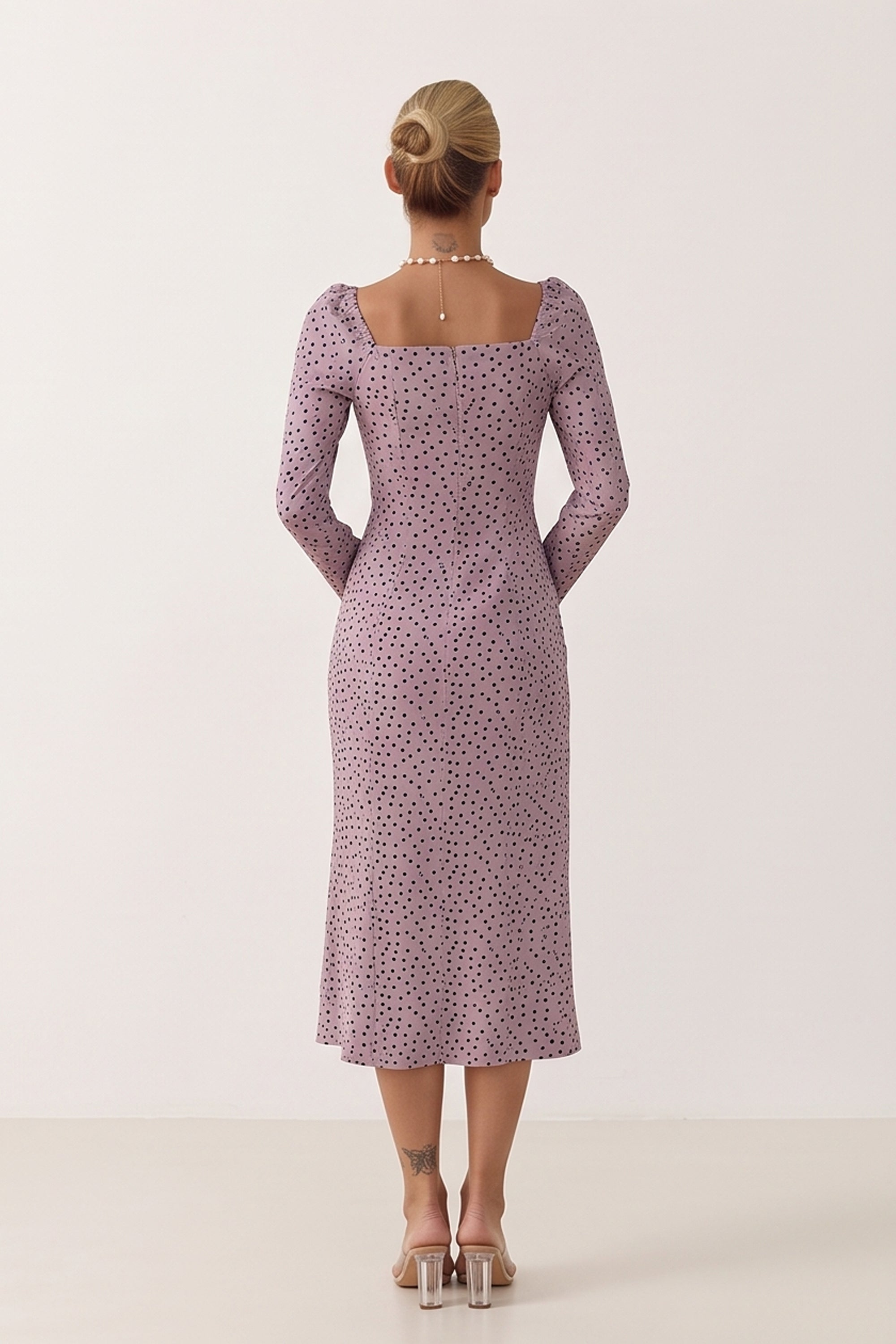 Back view of a woman wearing the pink Celestra Midi Dress by FemeAdor featuring a flattering fit-and-flare silhouette and timeless polka dot pattern