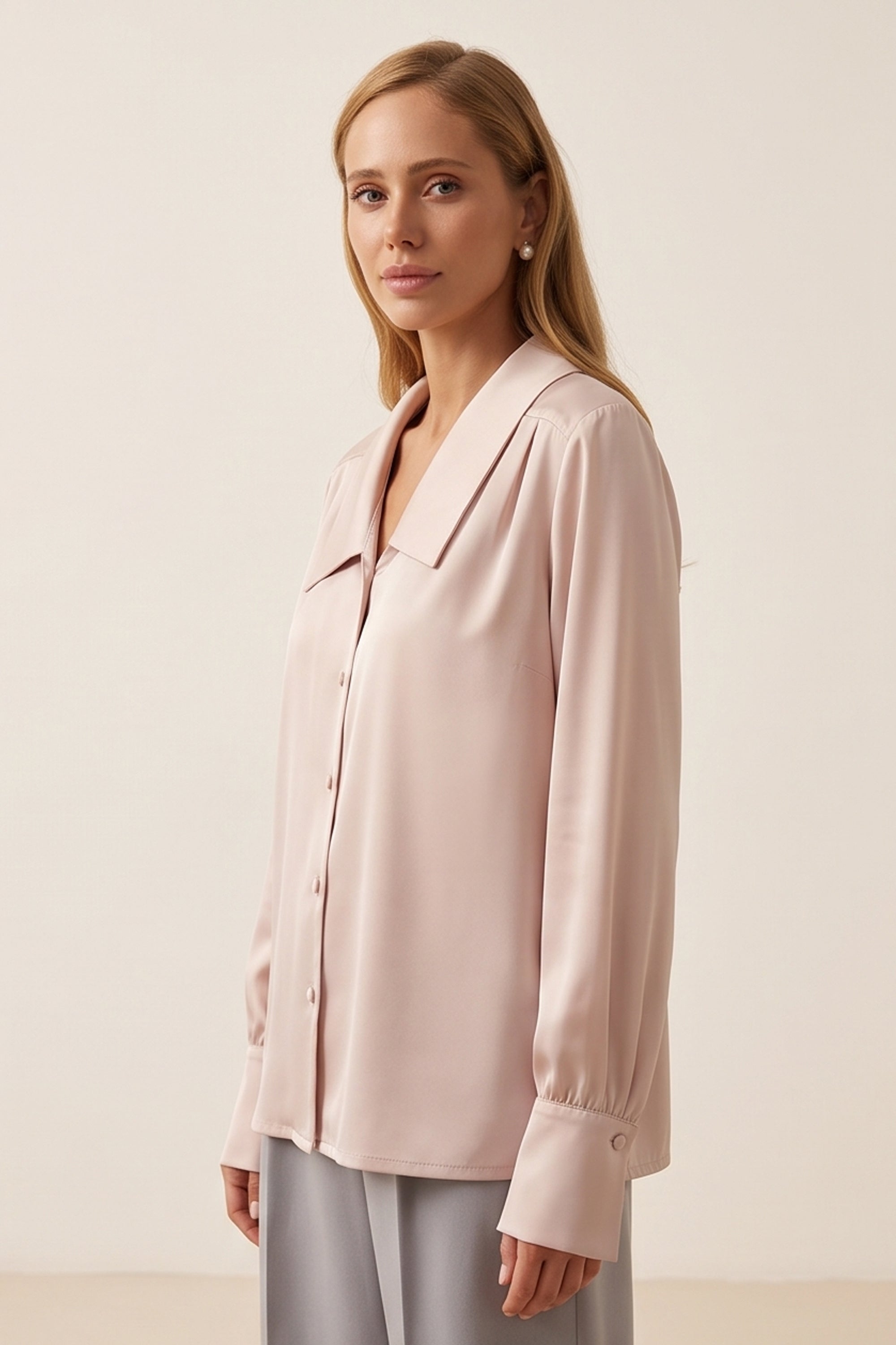 Side view of a woman wearing the pink Timeless Blouse by FemeAdor featuring a flattering fit, ideal for layering or wearing solo in professional and casual settings.