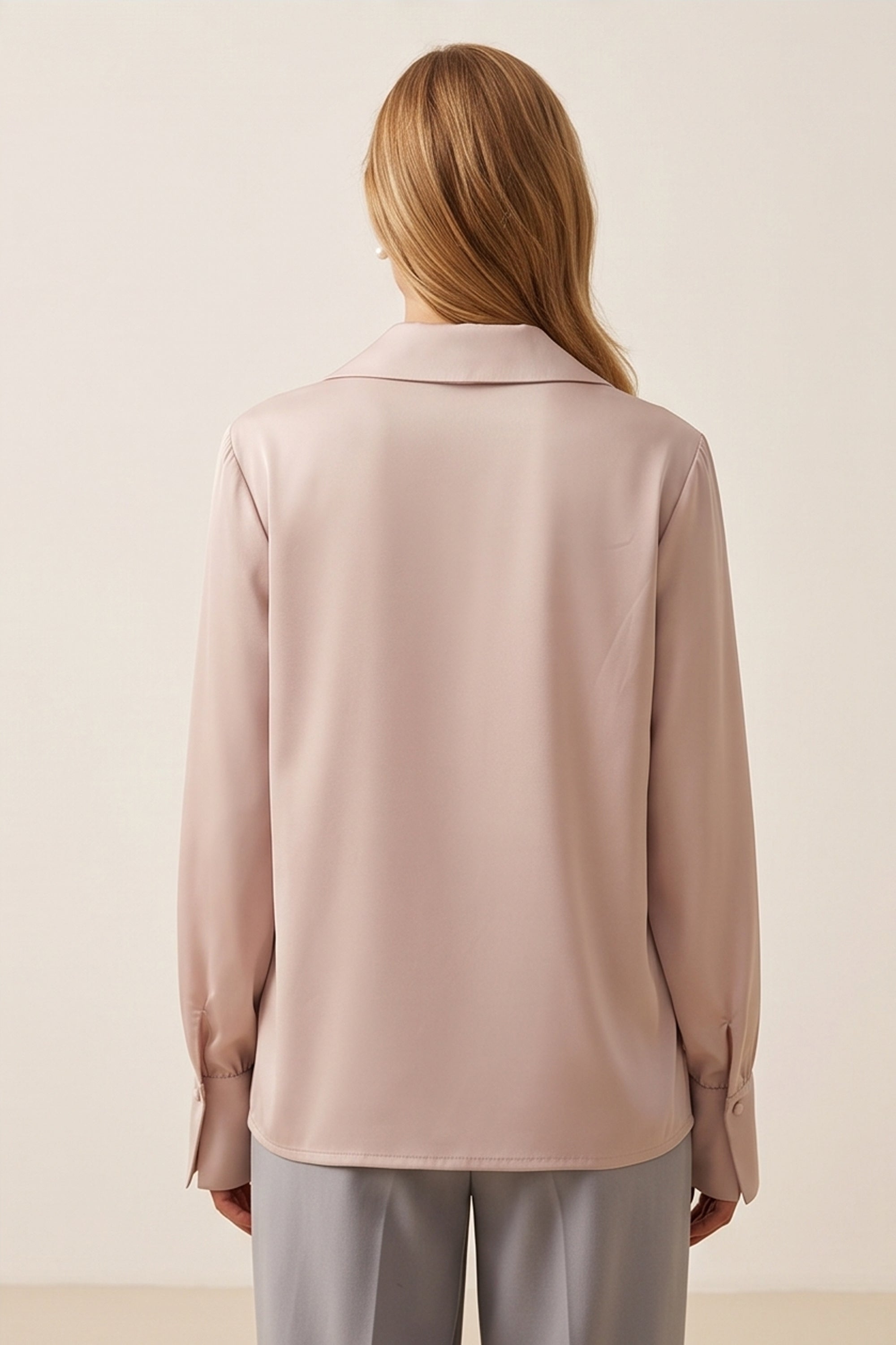 Back view of a woman wearing the pink Timeless Blouse by FemeAdor featuring a flattering fit, ideal for layering or wearing solo in professional and casual settings.