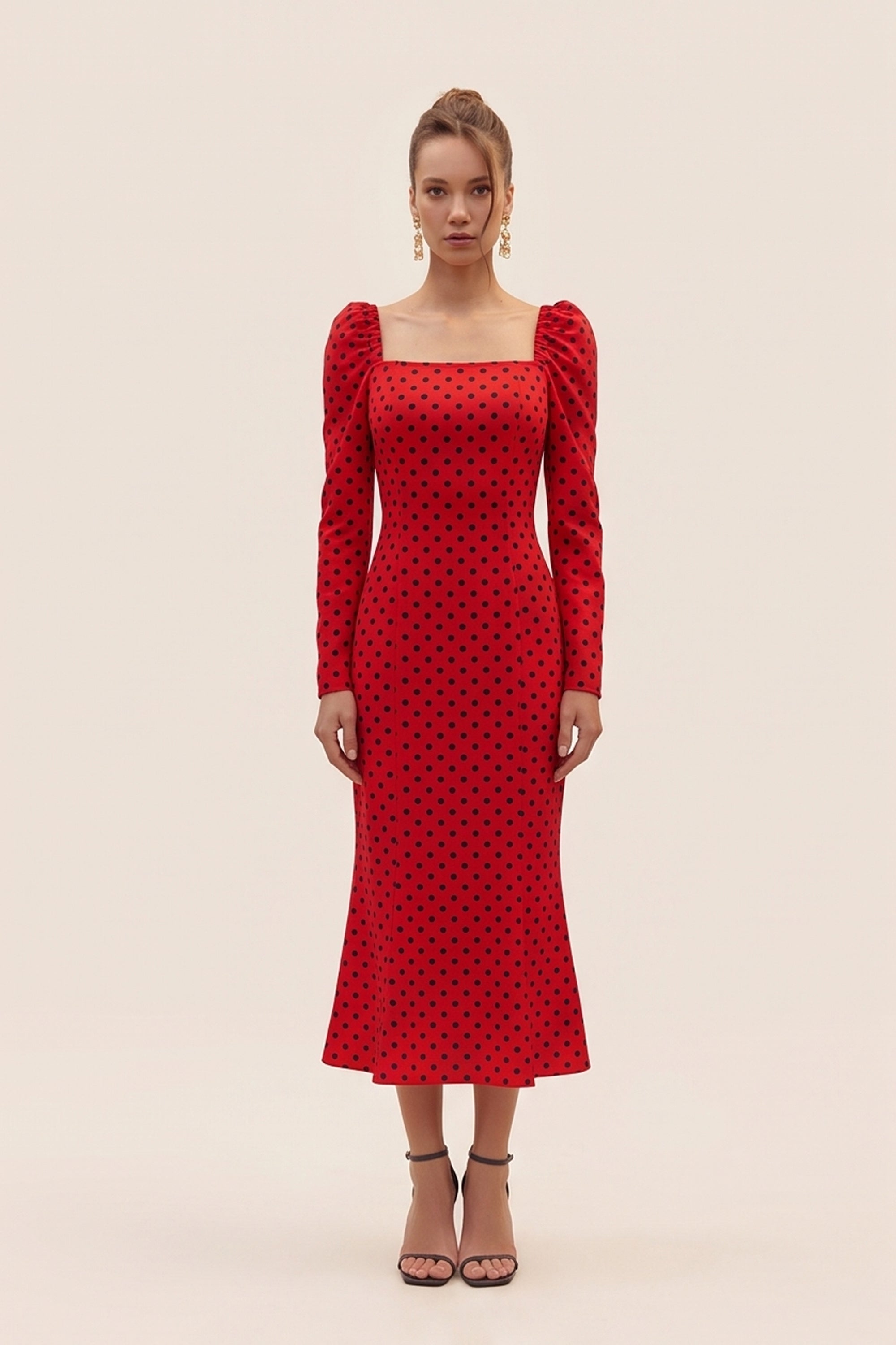 Front view of a woman wearing the red Celestra Midi Dress by FemeAdor featuring a flattering fit-and-flare silhouette and timeless polka dot pattern