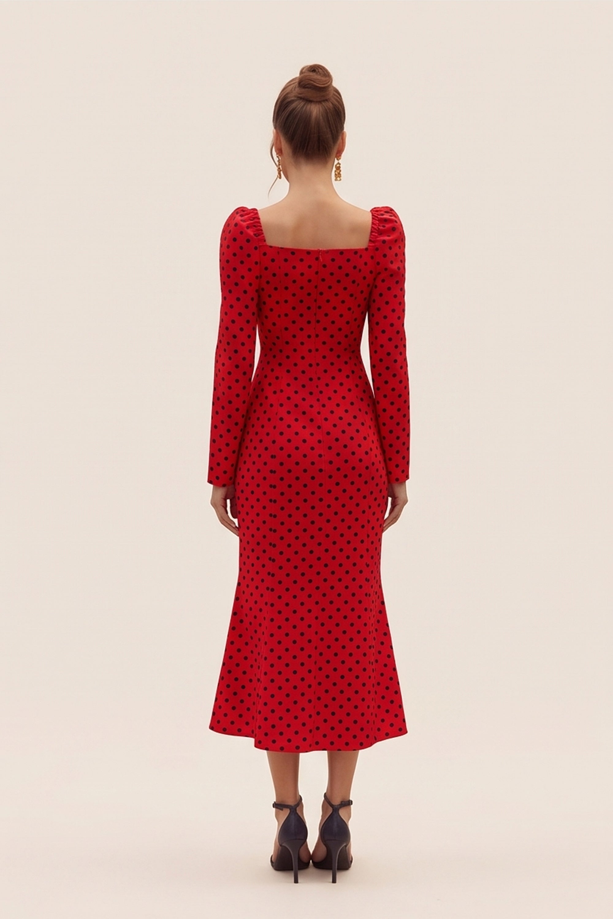 Back view of a woman wearing the red Celestra Midi Dress by FemeAdor featuring a flattering fit-and-flare silhouette and timeless polka dot pattern