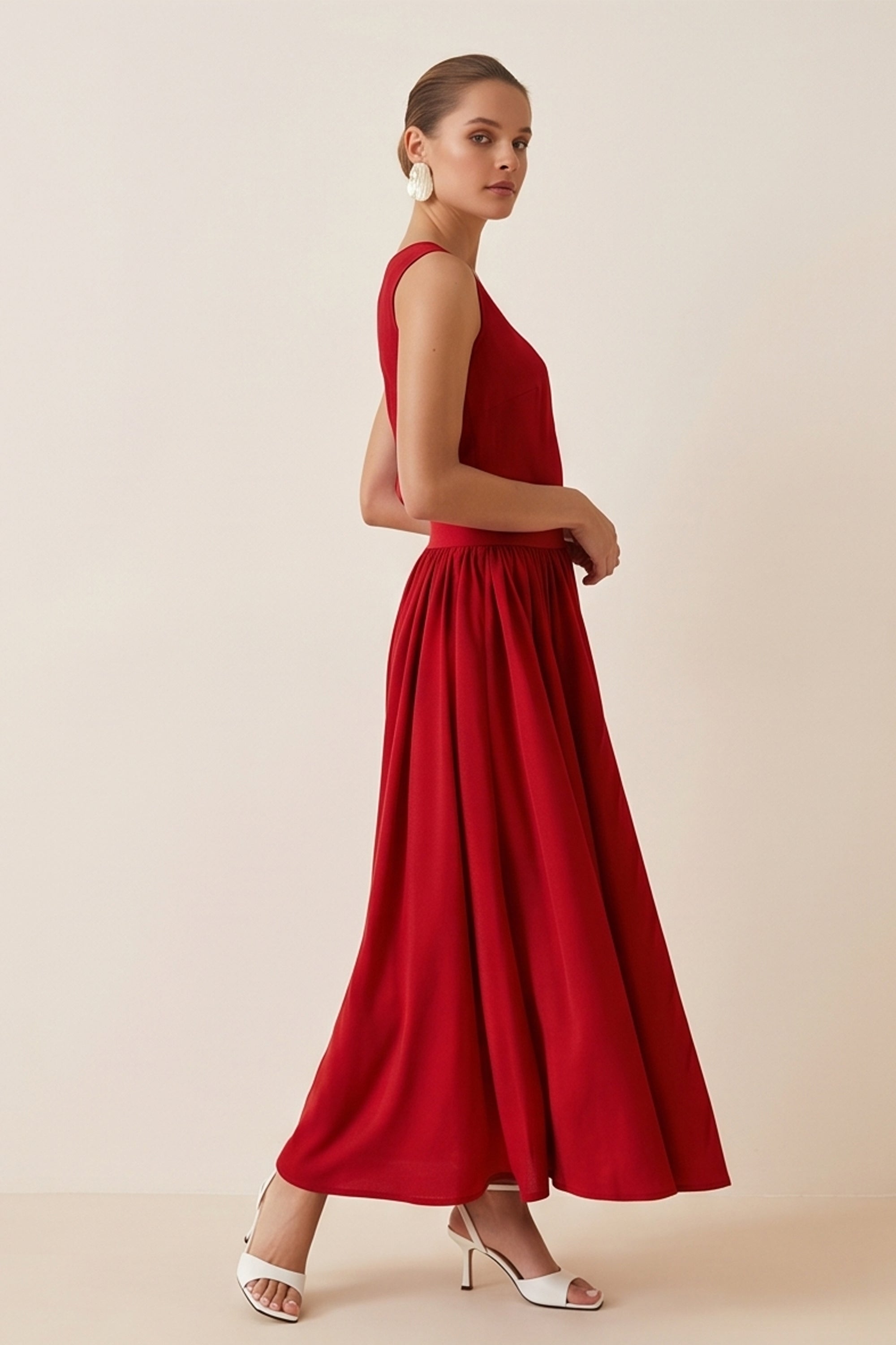 Side view of woman wearing the red Enchanting Skirt by FemeAdor featuring a flowing midi silhouette and soft fabric, ideal for casual or formal wear