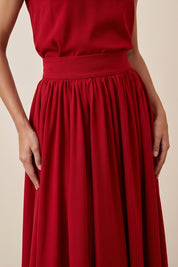 Close up view of a woman wearing the red Enchanting Skirt by FemeAdor featuring a flowing midi silhouette and soft fabric, ideal for casual or formal wear