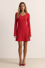 Front view of a woman wearing the red Velora Mini Dress by FemeAdor with long sleeves featuring a ribbed design and flattering fit for casual or evening wear