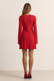 Back view of a woman wearing the red Velora Mini Dress by FemeAdor with long sleeves featuring a ribbed design and flattering fit for casual or evening wear