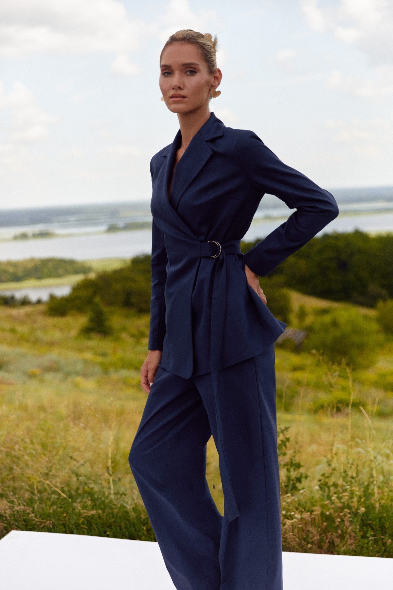 Side view of Regal Blazer by FemeAdor in navy blue featuring a tailored belted silhouette, ideal for professional and casual styling