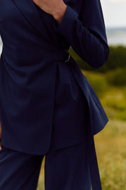 Close up of Regal Blazer by FemeAdor in navy blue featuring a tailored belted silhouette, ideal for professional and casual styling
