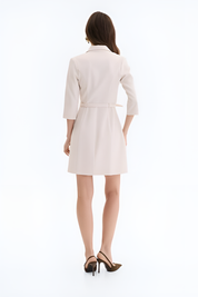Back view of a woman wearing the vespera mini dress-jacket in structured beige design by FemeAdor