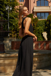 Side view of the Virella Maxi Dress in black with sleeveless design, open back, and floor-length silhouette for elegant evening wear