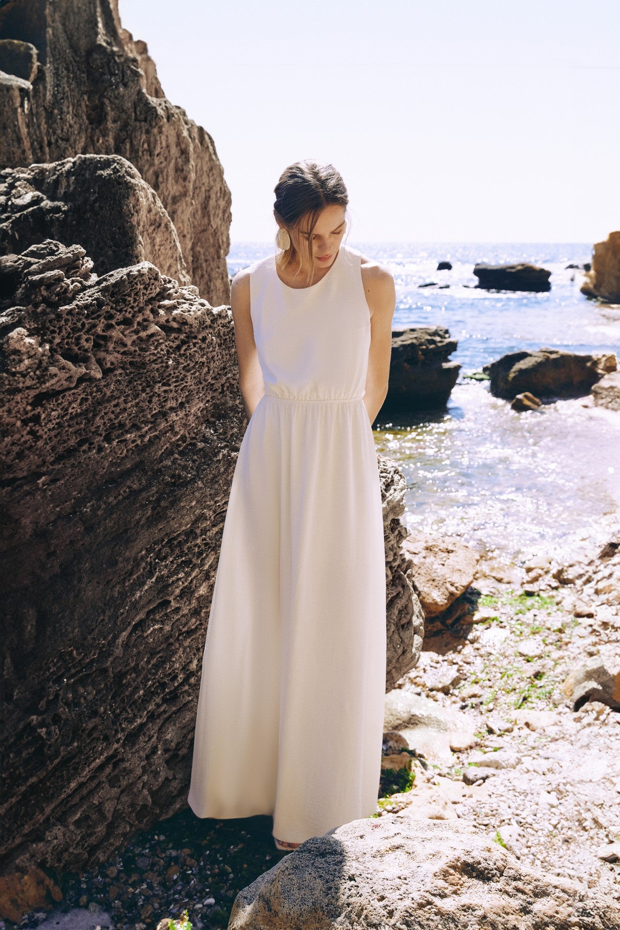 Front view of the Virella Maxi Dress in white with sleeveless design, open back, and floor-length silhouette for elegant evening wear