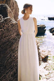Close up view of the Virella Maxi Dress in white with sleeveless design, open back, and floor-length silhouette for elegant evening wear