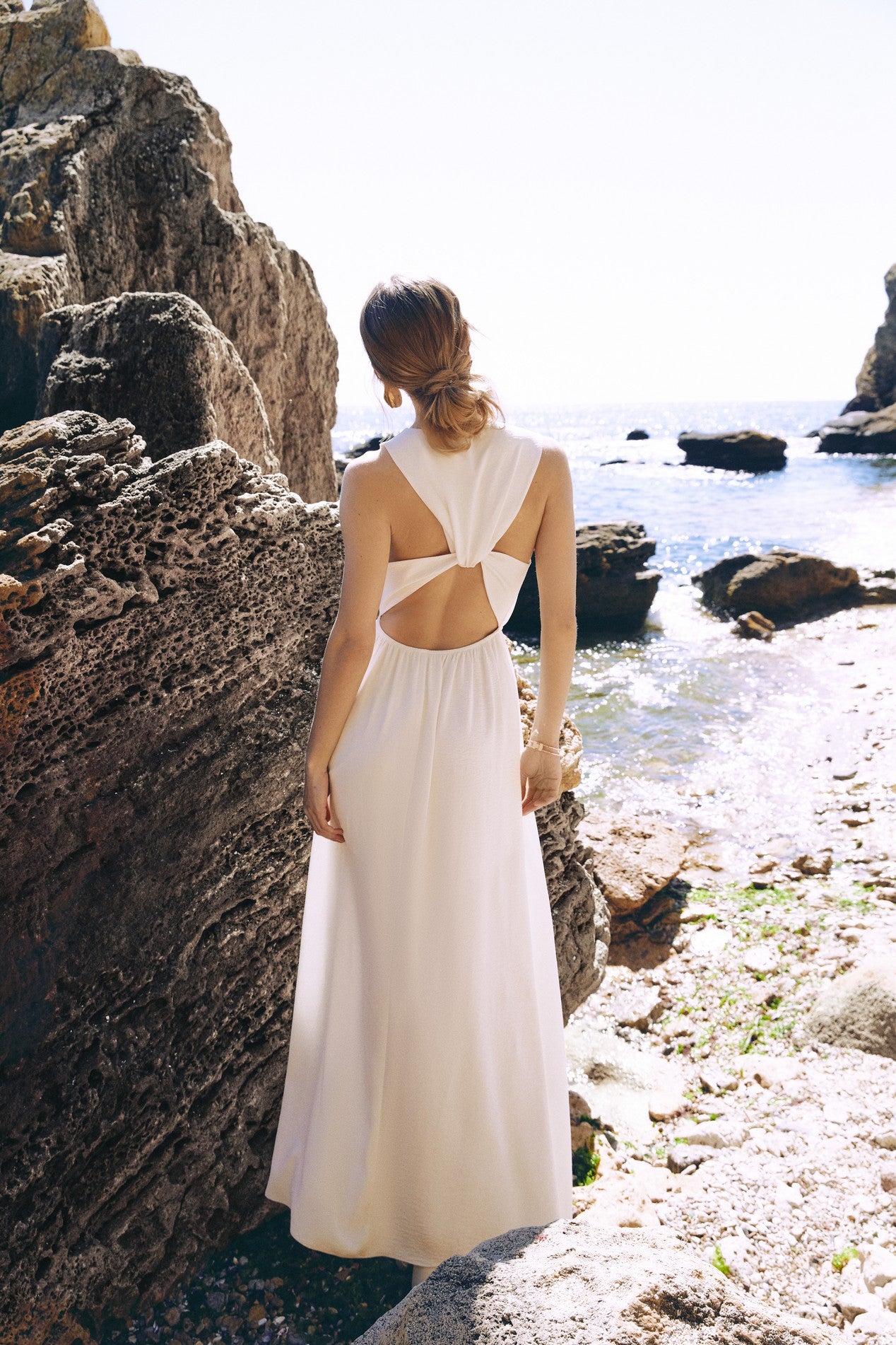Back view of the Virella Maxi Dress in white with sleeveless design, open back, and floor-length silhouette for elegant evening wear