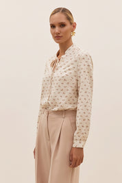 Side view of a woman wearing the white Floral Blouse by FemeAdor featuring a delicate floral print and tie detail, perfect for casual or polished looks