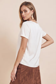Side view of a woman wearing the white Pearl T-shirt by FemeAdor with silk-like finish and relaxed flattering fit
