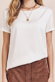 Close up view of a woman wearing the white Pearl T-shirt by FemeAdor with silk-like finish and relaxed flattering fit
