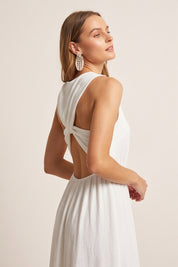 Close up view of a woman wearing the white Virella Maxi Dress with sleeveless design, open back, and floor-length silhouette for elegant evening wear